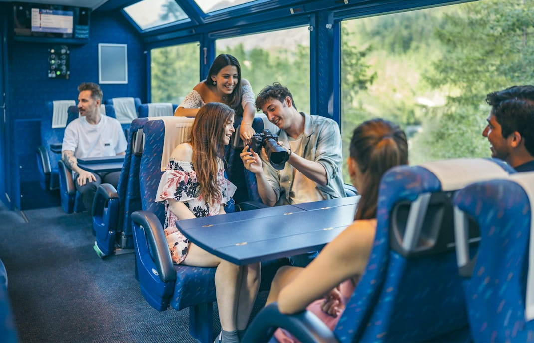 Friends relaxing in second class seats on the Golden Pass train, Switzerland.
