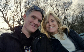 Couple enjoying a romantic moment on a bench in Stockholm park during self-guided city exploration.