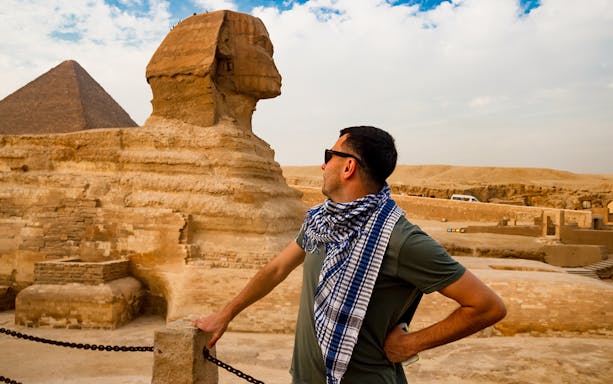 Man observing the Sphinx and Giza Pyramid during Cairo half-day tour.