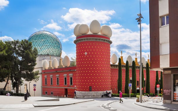 Dalí House Museum in Figueres with red facade and egg sculptures, view from the square.