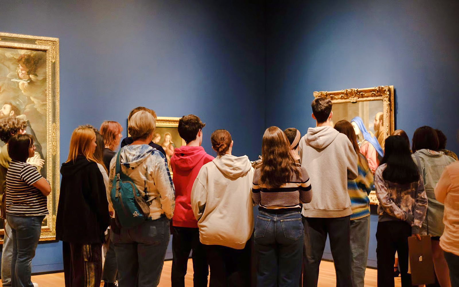 Visitors viewing paintings at Seattle Art Museum exhibition.