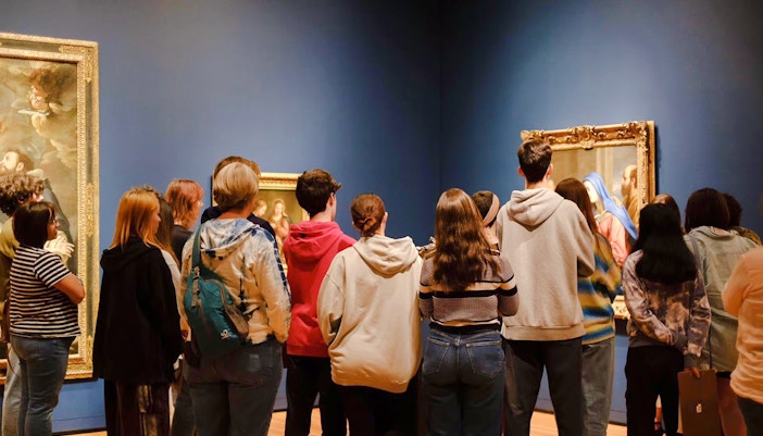 Visitors viewing paintings at Seattle Art Museum exhibition.