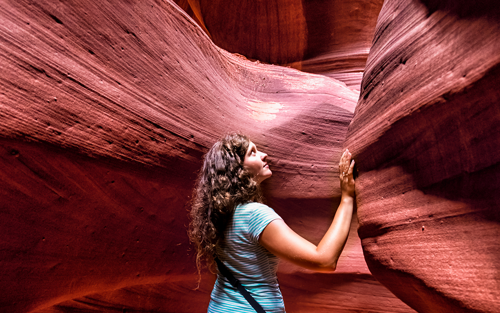 Young woman exploring the sandstone formations of Antelope Canyon.