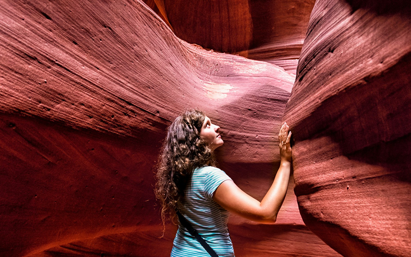 Young woman exploring the sandstone formations of Antelope Canyon.