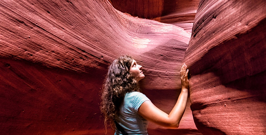 Young woman exploring the sandstone formations of Antelope Canyon.