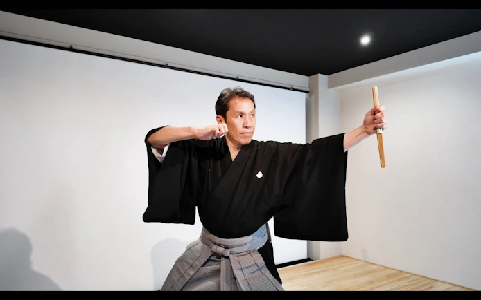 Noh performer demonstrating a pose in a Kyoto theater workshop.