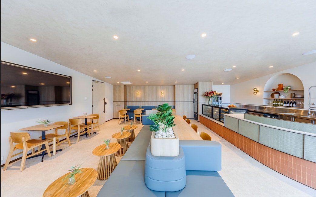 Plaza Premium Lounge seating area with tables, chairs, and a counter for international arrivals.