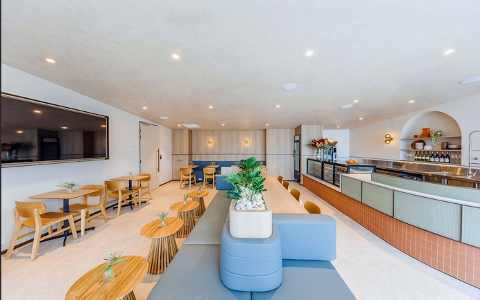 Plaza Premium Lounge seating area with tables, chairs, and a counter for international arrivals.