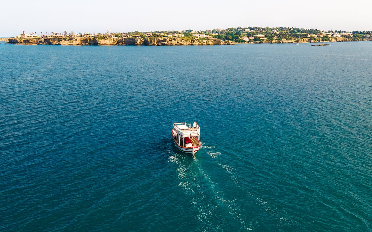 Boat cruising near Syracuse coastline on a guided tour with lunch and wine.