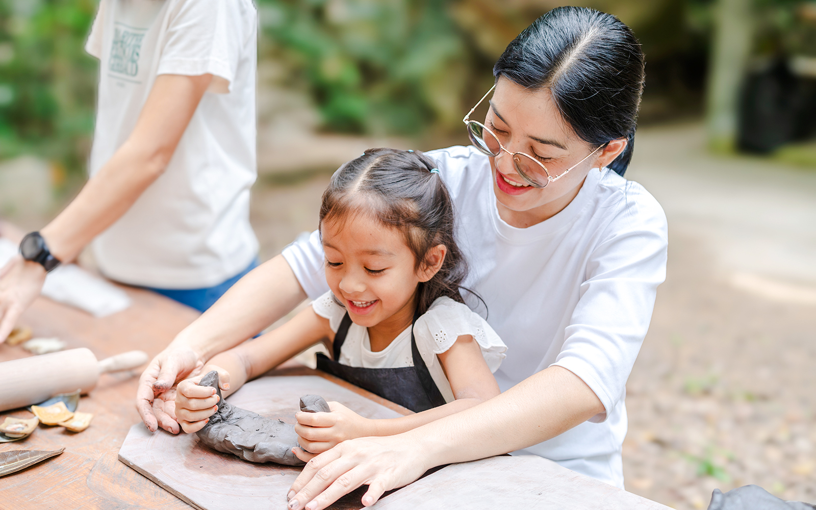 Child and adult sculpting clay at Musée en Herbe Paris workshop.