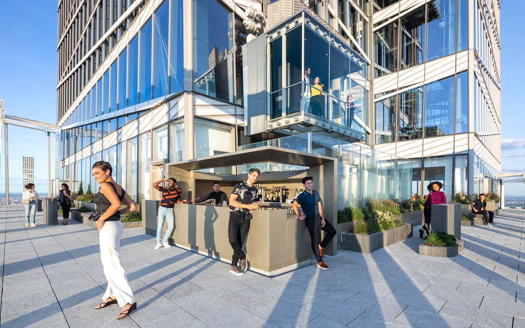 Visitors enjoying the view and outdoor bar at the top floor of SUMMIT One Vanderbilt, New York City.
