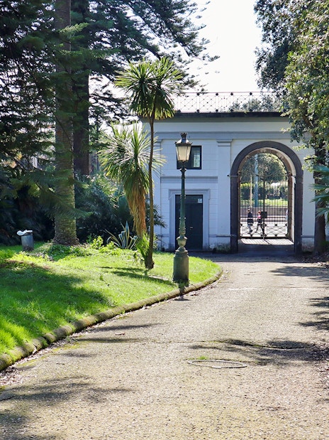 Villa Pignatelli entrance with archway and surrounding greenery in Naples, Italy.