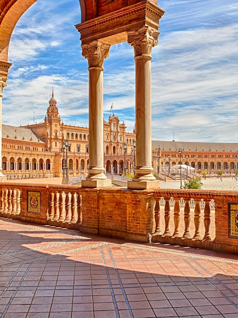 Spain Square in Seville with arched walkways and central fountain.