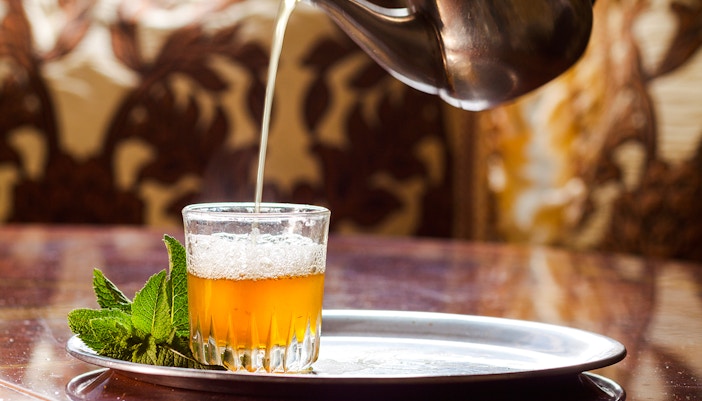 Moroccan mint tea being poured into a glass at Café Bousafsaf, Marrakech.