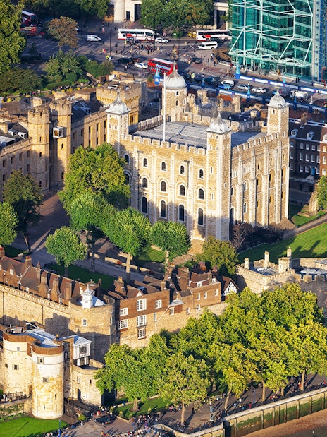 Aerial view of the Tower of London with surrounding walls and greenery.