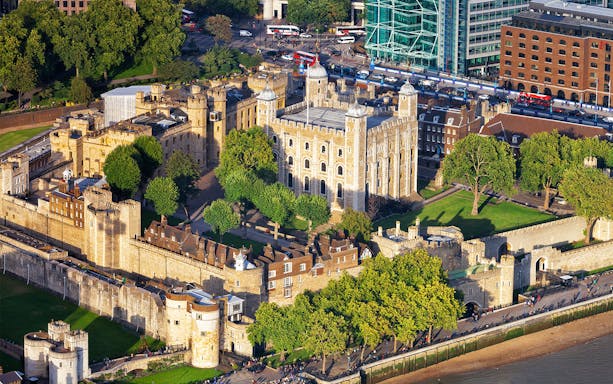 Aerial view of the Tower of London with surrounding walls and greenery.