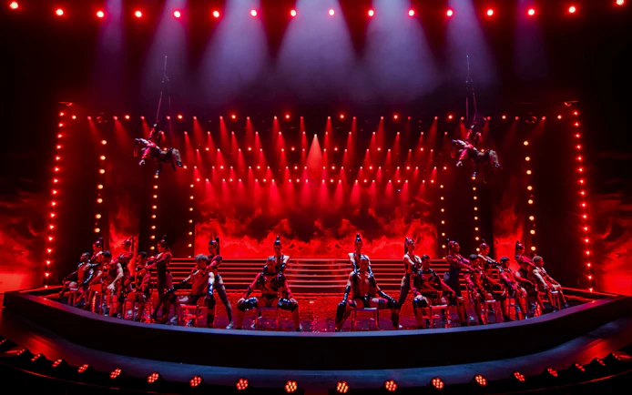 Performers on stage at Friedrichstadt Palast with dramatic red lighting.
