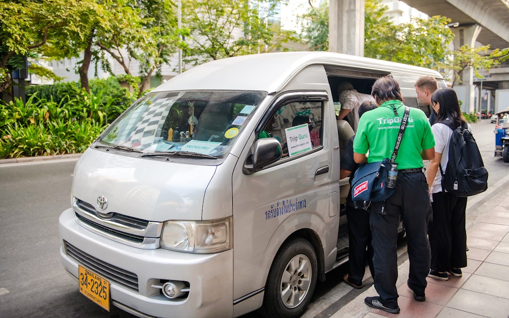 Tourists boarding a van for Ayutthaya historical temples tour transfer.