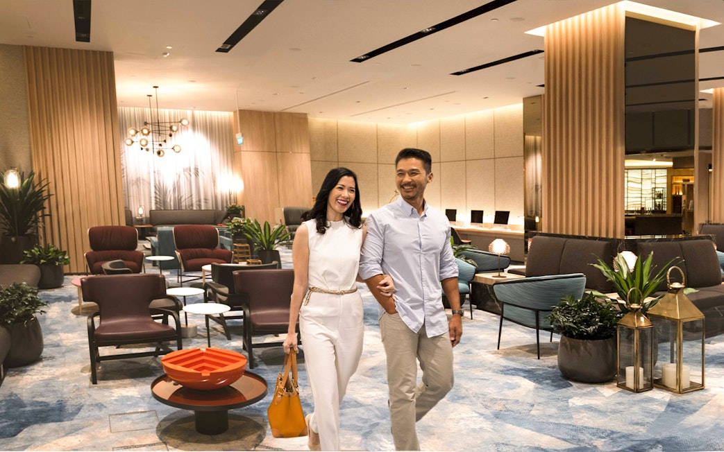 Couple walking in Changi Lounge, Singapore, surrounded by modern seating and decor.