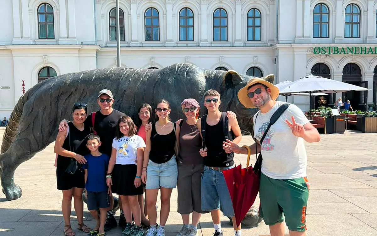 Group posing by the tiger statue at Oslo Central Station during Oslo Walking Tour.
