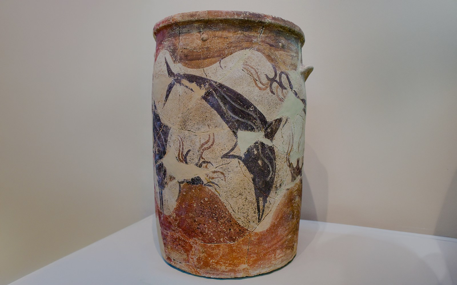 Ancient cylindrical pithos with dolphin and lily motifs from Akrotiri, Santorini, Greece.
