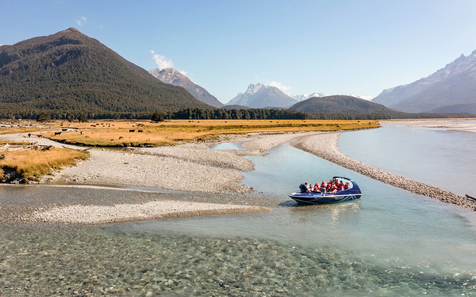 Jet boat on Dart River with mountains in the background, New Zealand.