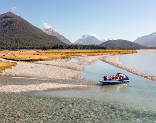 Jet boat on Dart River with mountains in the background, New Zealand.