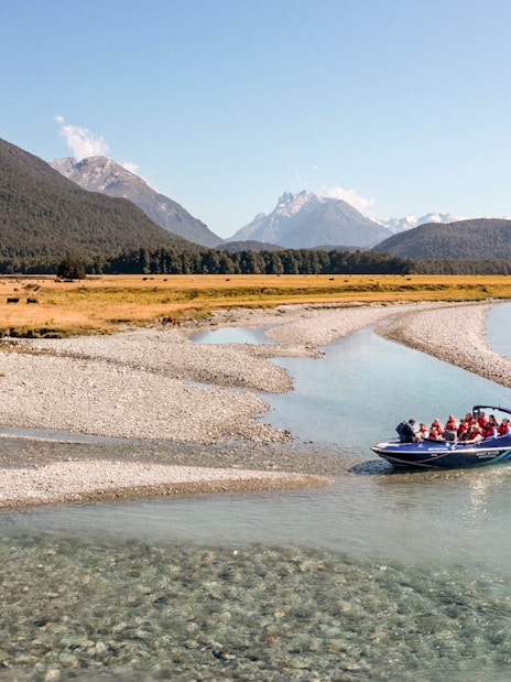 Jet boat on Dart River with mountains in the background, New Zealand.