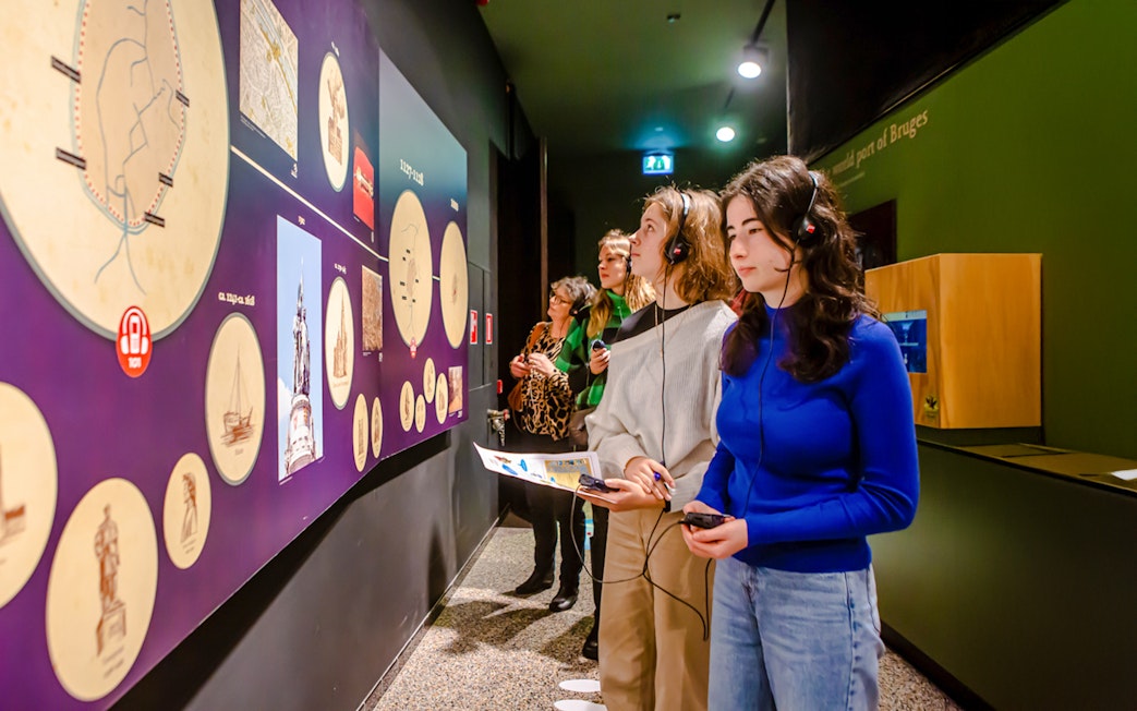 Visitors exploring exhibits with audio guides at Historium Bruges.