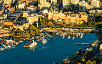 Aerial view of Victoria's Inner Harbour with boats and historic buildings, highlighting the seaplane tour route.