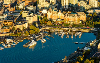 Aerial view of Victoria's Inner Harbour with boats and historic buildings, highlighting the seaplane tour route.