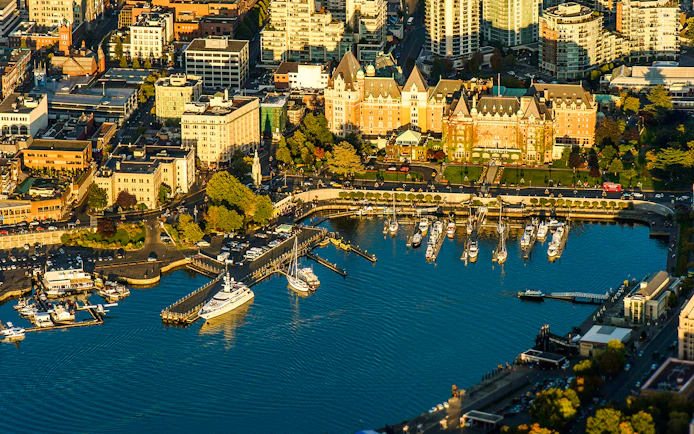 Aerial view of Victoria's Inner Harbour with boats and historic buildings, highlighting the seaplane tour route.