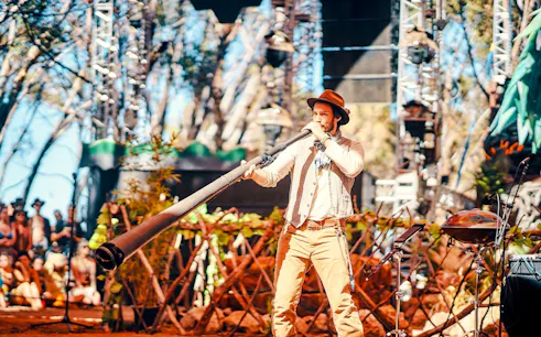 Musician playing didgeridoo at outdoor event, part of "Into Stillness: A Sound Journey" in London.
