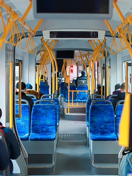 Passengers seated inside Edinburgh Airport transfer bus.