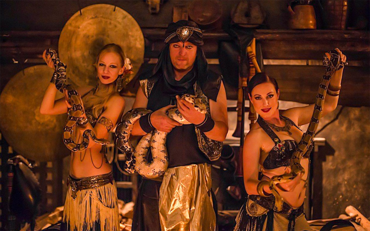 Medieval dinner show with snake dancers holding pythons.