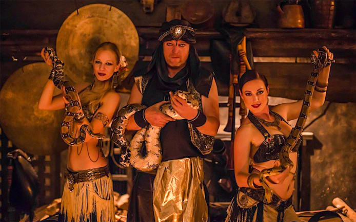 Medieval dinner show with snake dancers holding pythons.