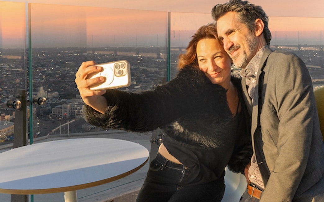 Couple taking a selfie at Vue Orleans Observation Deck during sunset.