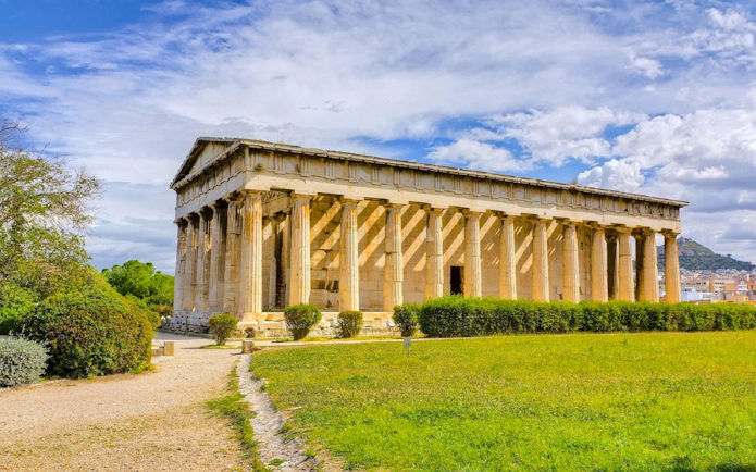 Temple of Hephaestus in the Ancient Agora of Athens, Greece, surrounded by greenery.