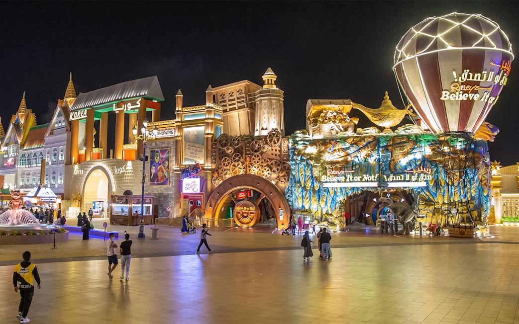 Global Village Dubai at night with Korea Pavilion and Ripley's Believe It or Not attractions.