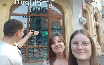 Group taking a selfie in front of a historic building in Bucharest during Dracula's Secret Journal tour.