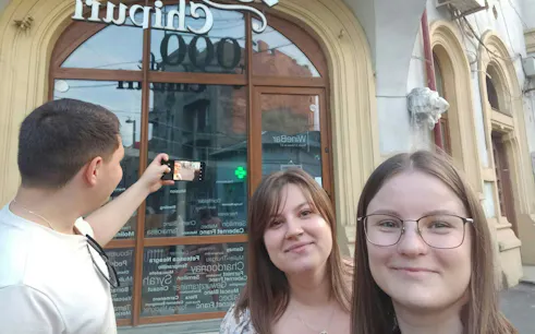 Group taking a selfie in front of a historic building in Bucharest during Dracula's Secret Journal tour.