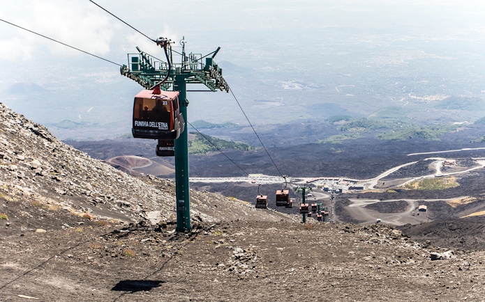 Mount Etna cable car ascending volcanic landscape in Sicily.