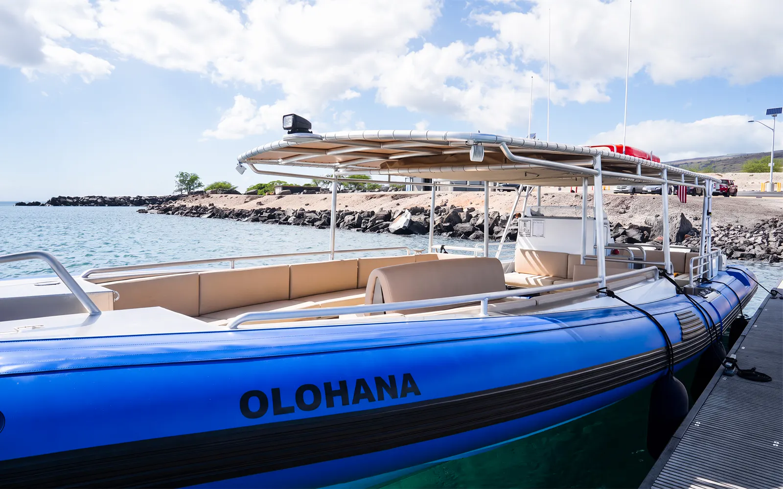 Boat docked on Big Island’s Kohala Coast with rocky shoreline in background.