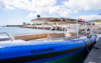 Boat docked on Big Island’s Kohala Coast with rocky shoreline in background.