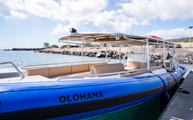 Boat docked on Big Island’s Kohala Coast with rocky shoreline in background.