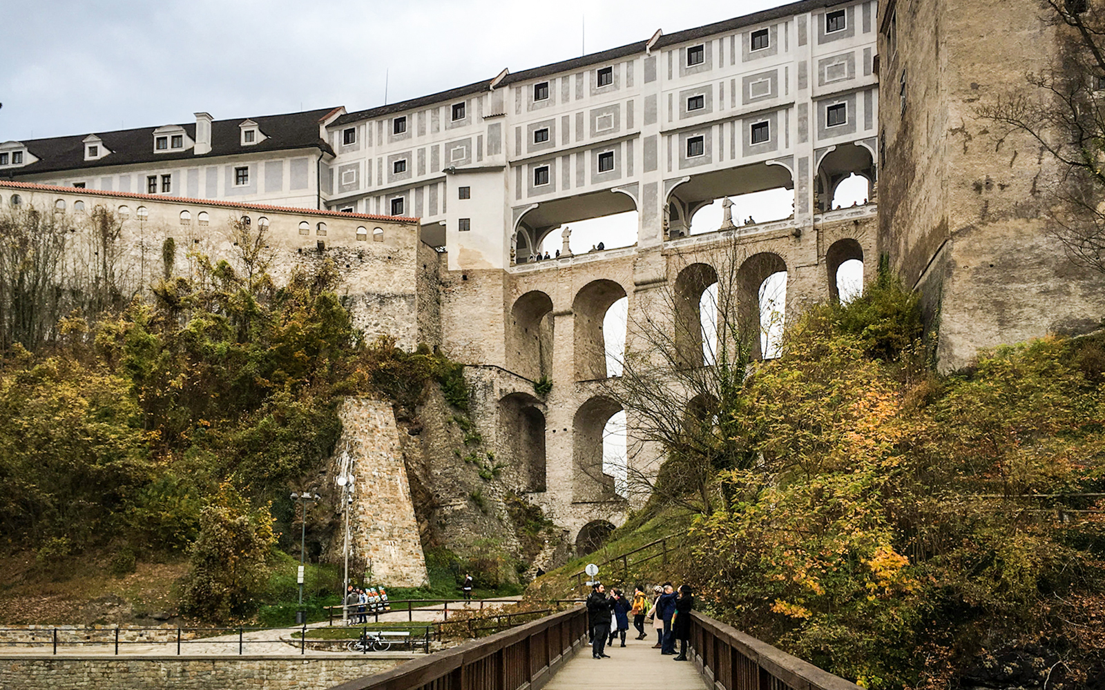 Cloak Bridge in Cesky Krumlov with tourists walking below.
