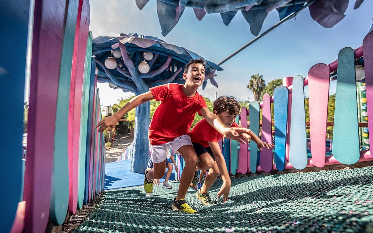 Children playing on a colorful playground at Isla Mágica, Seville.