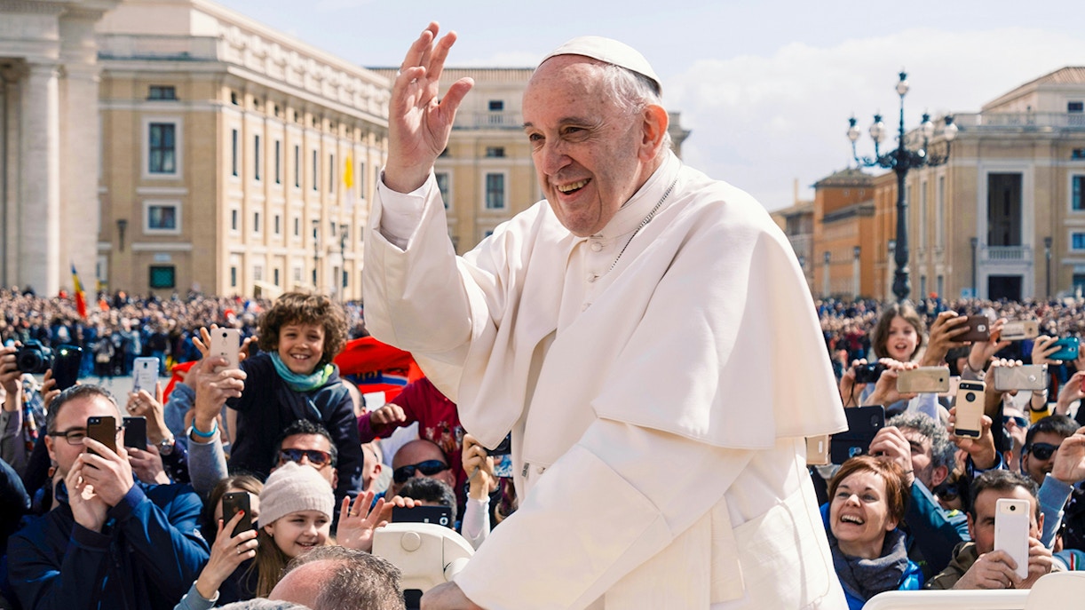 Pope Francis greeting crowd in a gathering.