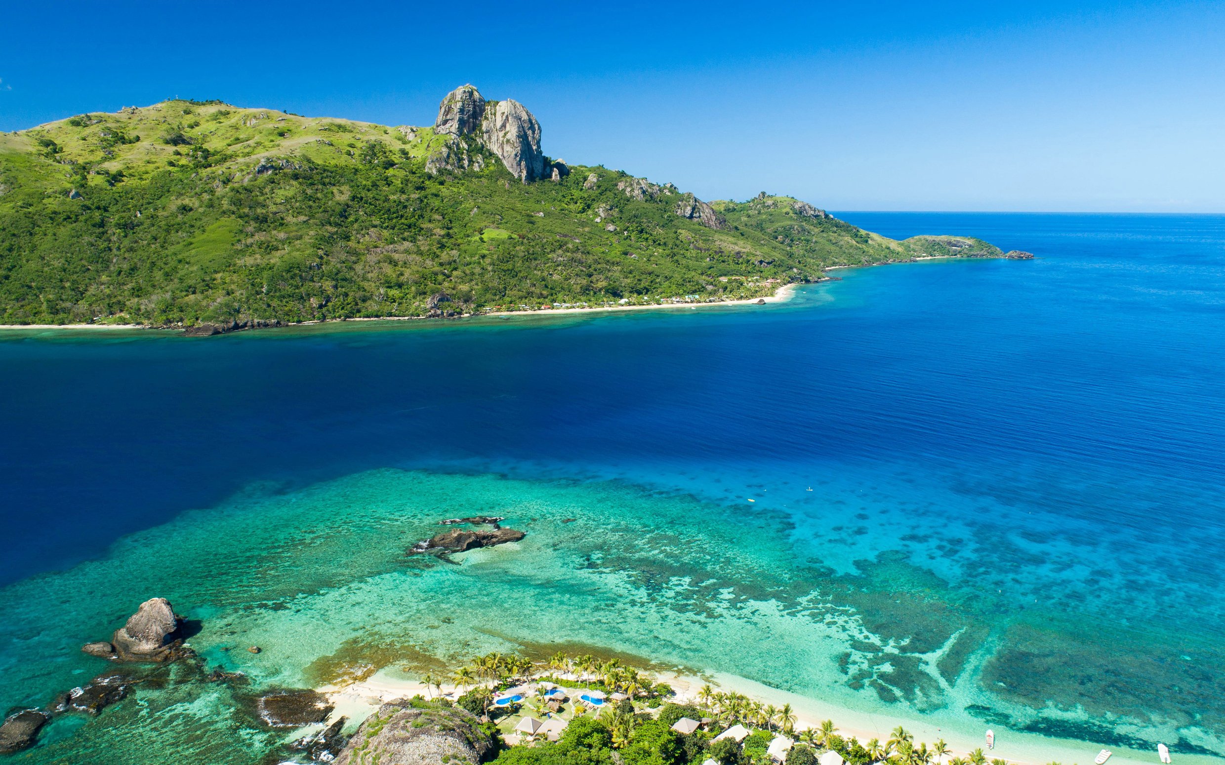 Panoramic view of Kuata Island's coastline and clear blue waters, Fiji.