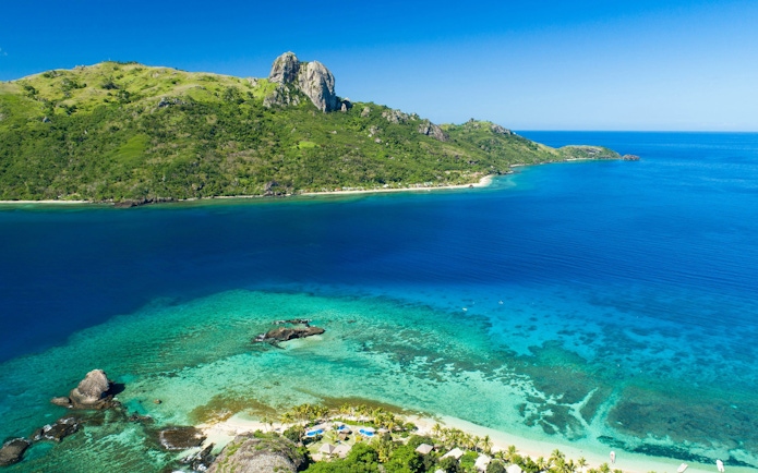 Panoramic view of Kuata Island's coastline and clear blue waters, Fiji.